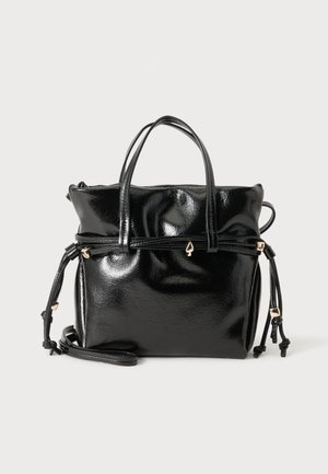Sac à main en cuir noir brillant avec doubles poignées, bandoulière réglable, côtés à cordon de serrage et petits accents dorés en forme de pique.