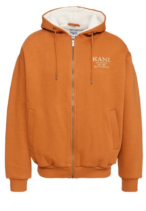 Orange zip-up hoodie med en fluffig vit foder, med en logo på bröstet, sidofickor och ribbade muddar och fåll.