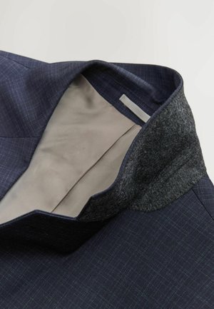 Marineblå blazer med ternet mønster, filtkrave og beige foret indeni. Tekstureret stof med en struktureret design.