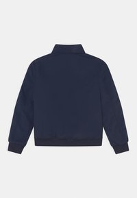 Granatowa kurtka bomberka z kołnierzem, ściągaczami przy mankietach i na pasku u dołu. Gładka, lekka tkanina. Prosty design, bez widocznych dodatków ani wzorów.