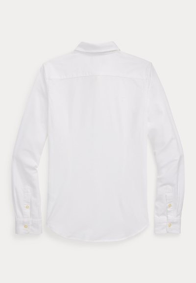 Camisa blanca de manga larga con botones, vista desde atrás con cuello doblado y puños abotonados sobre fondo liso.