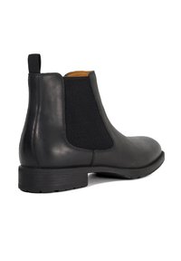 Black leather chelsea boot featuring elastic side panels, a textured finish, and a durable rubber sole. Includes a pull tab for easy wear.