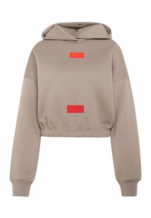 Lysebrun cropped hættetrøje med lange ærmer, elastisk taljebånd og to små røde rektangulære logoer på bryst og talje.
