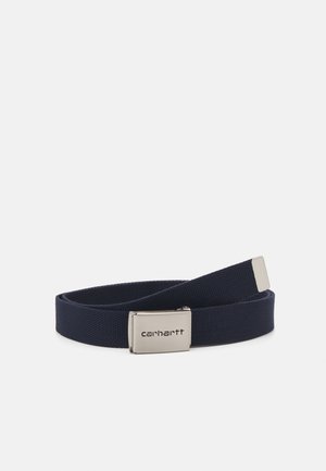 Ceinture tissée bleu marine avec une boucle en métal argenté arborant le logo Carhartt. La ceinture présente une texture lisse et un design minimaliste.