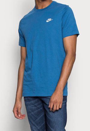 Blauwe katoenen t-shirt met een ronde hals en korte mouwen, voorzien van een wit Nike-logo op de borst en een zachte textuur. Gecombineerd met blauwe jeans.