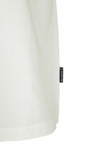 Witte katoenen T-shirt met een rechte snit. Bevat een klein zwart label aan de zijkant met rode en blauwe verticale accenten. Zachte textuur.