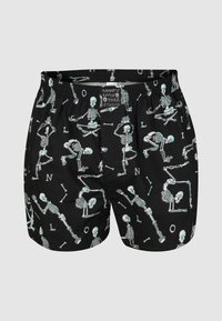 Schwarze Boxershorts mit einem verspielten Skelettmuster in Hellblau. Elastischer Bund mit sichtbarem Markenlabel. Weicher Stoff.