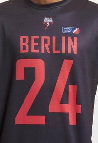 Čierny športový dres vyrobený z ľahkej sieťoviny, s červeným textom "BERLÍN" nad číslom "24" a logami Berlin Thunder a Európskej ligy.