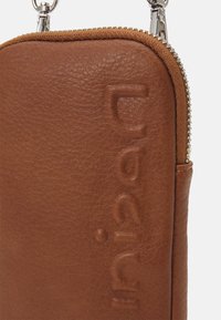 Brązowa skórzana saszetka o fakturowanej powierzchni z wytłoczonym logo "Fjällräven", srebrny metalowy zamek błyskawiczny oraz zaczepy na klips u góry.