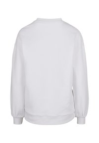 Valkoinen collegepaita, jossa on pitkät hihat, resorit hihansuissa ja helmassa sekä klassinen pyöreä pääntie. Sileä pinta ja rento istuvuus.