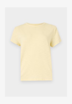 Μαλακό, ανοιχτό κίτρινο T-shirt κοντούς μανίκες με λαιμόκοψη, σε απλό σχέδιο, παρουσιάζεται σε επίπεδο, φωτεινό γκρι φόντο.