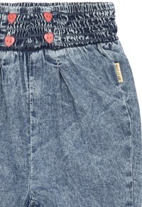 Pantaloni in denim con cintura arricciata, caratterizzati da tre bottoni rosa, di colore azzurro chiaro e design con pieghe sul davanti. Etichetta sul lato.