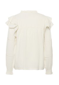 Blouse blanche texturée avec manches à volants, col froncé et détails en dentelle sur les manches. Le tissu semble léger et aérien.