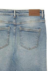 Jeans in denim blu con una finitura sbiadita, dotati di due tasche posteriori, cuciture in vista e una patta in pelle marrone nella vita.