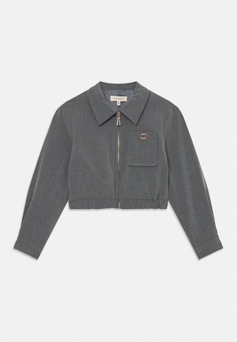 Pilkas trumpas švarkas su apykakle, priekiniais užtrauktukais, vienu krūtiniu kišeniu ir auksine detalė. Pagamintas iš tekstūrinio audinio.