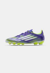 Violette en groene voetbalschoenen met een gestroomlijnd ontwerp, een gestructureerde bovenkant en witte accenten. Voorzien van een lichte zool met gevormde noppen.