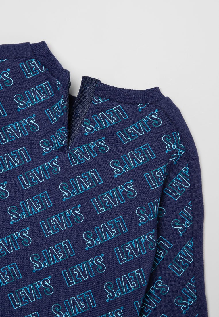 Top de cuello redondo azul marino con un patrón repetido de texto "LEVI'S" en turquesa, con un cierre de cremallera y textura acanalada en el cuello.
