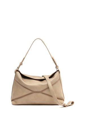 Beige skuldertaske i læder med justerbare dobbelte stropper og dekorativt syet X-mønster foran, hvilende på hvid baggrund.