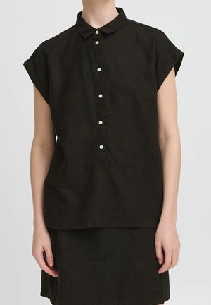 Camisa negra de manga corta con cuello clásico, cierre frontal con botones y corte holgado. Fabricada con tejido texturizado que presenta un brillo sutil.