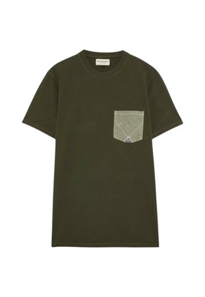 T-shirt verde oliva a maniche corte in cotone, con una tasca sul petto di un verde chiaro a contrasto, dotata di un accento triangolare e dettagli cuciti.