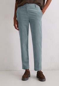Lichtblauwe corduroy broek met een recht gesneden ontwerp, met zijzakken en een zachte textuur. Gepaard met bruine instap schoenen.