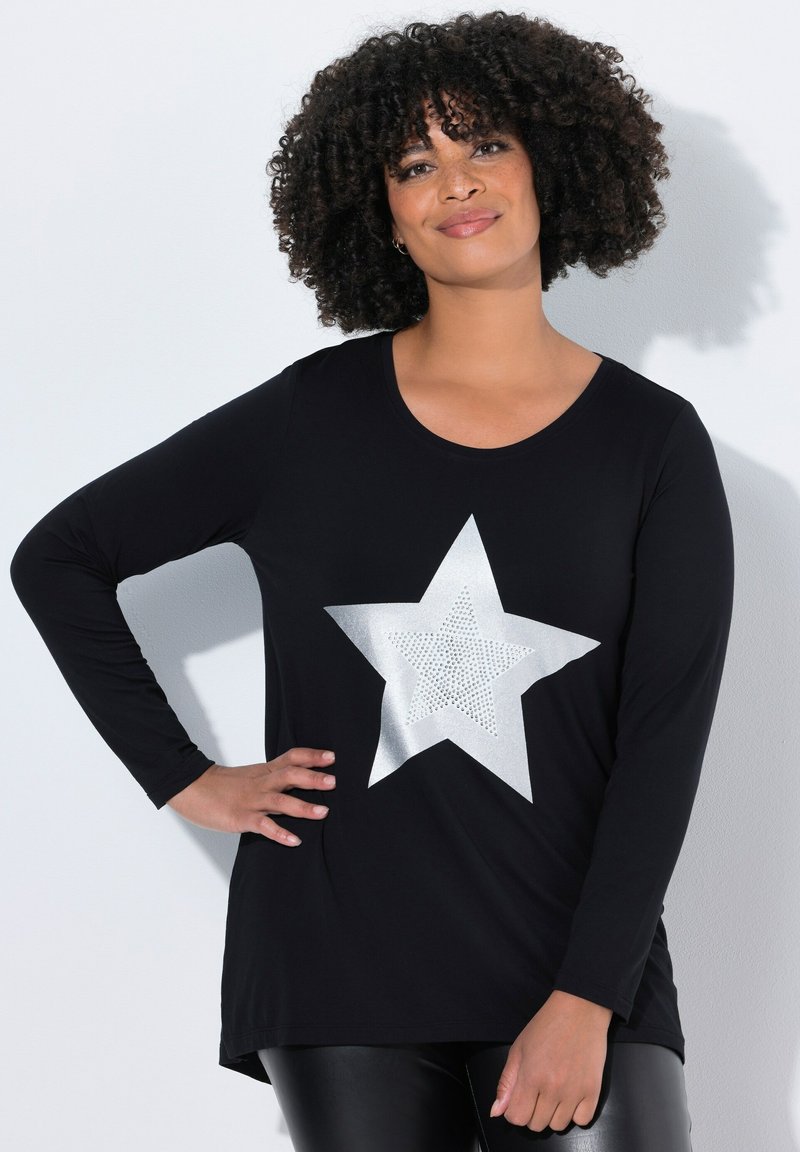 Zwarte langemouwen top met een groot zilveren sterontwerp en een gestructureerd patroon. De stof lijkt zacht en iets getailleerd bij de taille.