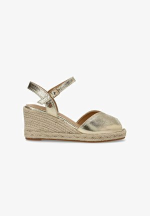 Espadrilles de cuña metálica dorada con punta descubierta, correa ajustable en el tobillo y suela de plataforma de yute trenzado. Textura suave en general.