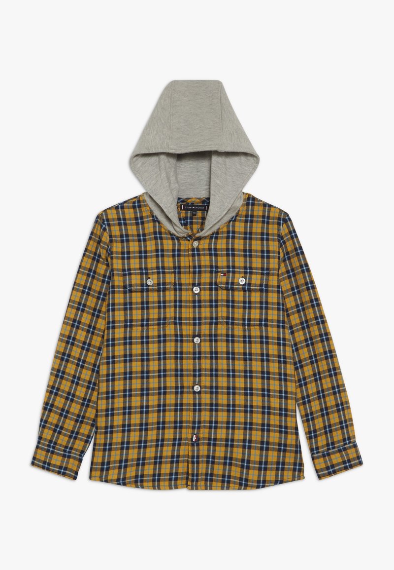 Chemise à carreaux jaune et marine avec une capuche grise, dotée de deux poches poitrine, de fermetures à boutons et de manches longues. Texture de tissu douce.