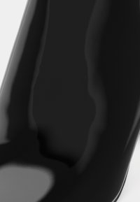 Scarpa nera con tacco alto e finitura lucida in patent, caratterizzata da una forma affusolata e una superficie liscia. Nessuna ferramenta o motivo visibile.