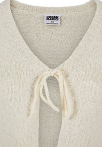 Cream knitted cardigan with a soft, textured finish, featuring a V-neck and a tie closure at the front. Label reads "Urban Classics, XS."