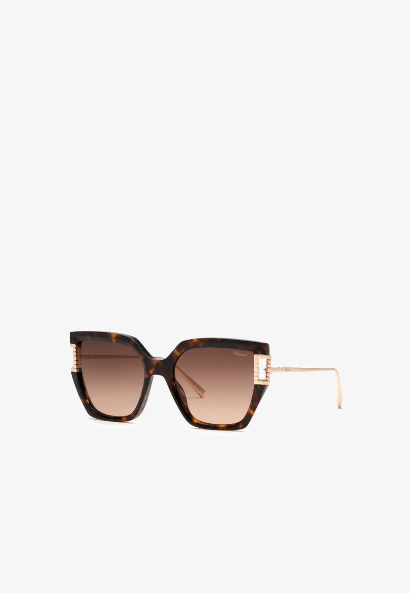Lunettes de soleil carrées en écaille avec verres marron dégradés et branches et charnières en métal doré.