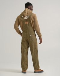 Salopette rayée olive en tissu texturé, avec des bretelles réglables, des poches latérales et une étiquette au dos. Sweat à capuche marron en dessous.