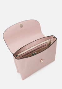 Clutch de cuero texturizado rosa claro con solapa abierta, mostrando forro interior beige, un bolsillo con cremallera y cierre de botón magnético.