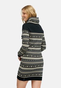 Strickkleid mit hohem Kragen, geometrischen Mustern in Schwarz und Creme, langen Ärmeln und einer taillierten Silhouette mit gerippten Bündchen.