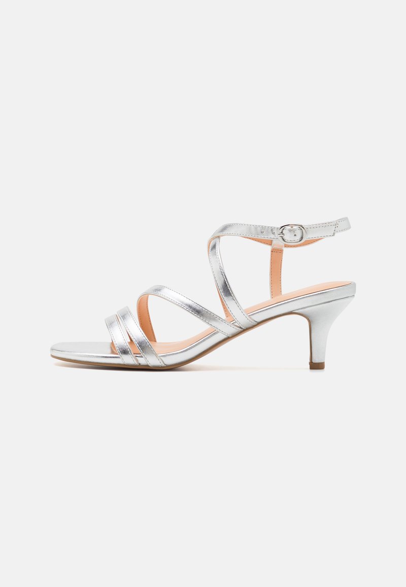 Sølvstrappet hæl sandal med lav blokhæle, metallisk tekstur, justerbar ankelrem og åben tå design. Glat indersål.