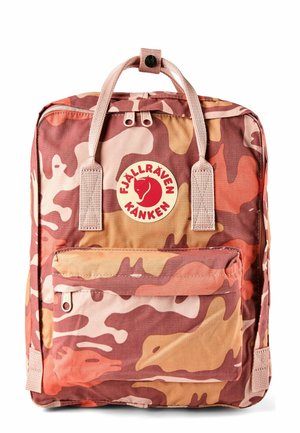 Sac à dos rectangulaire à motif camouflage rose et marron, poche avant zippée, double poignée supérieure et écusson circulaire rouge.