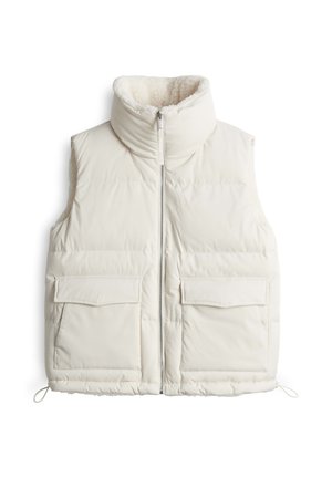 Gilet imbottito colore avorio, con colletto alto, chiusura con zip e due tasche frontali a toppa. Fodera morbida e strutturata per il calore.