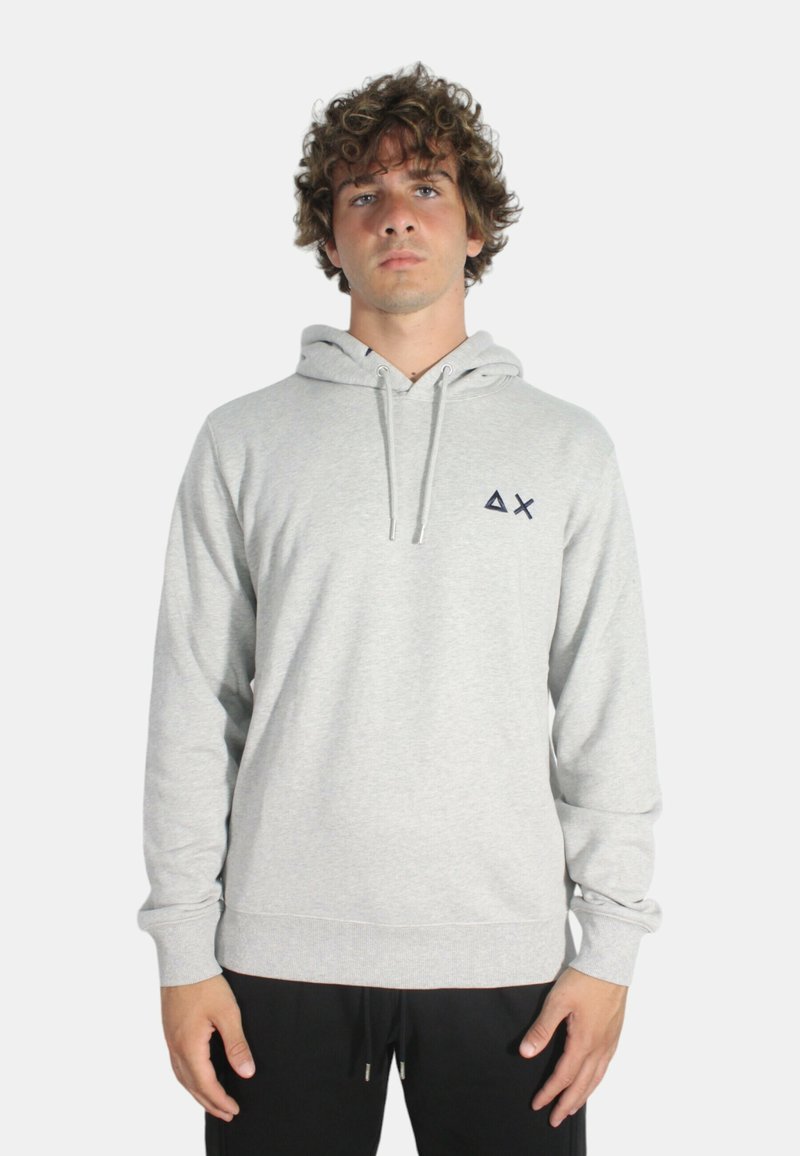 Felpa grigia con cappuccio regolabile, polsini a costine e un piccolo logo scuro sul petto. Tessuto morbido e vestibilità rilassata.