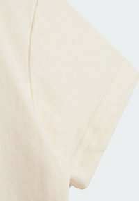 Korte mouwshirt van lichtbeige katoen met een soepele textuur en een subtiel ribbelpatroon, voorzien van netjes gestikte randen.