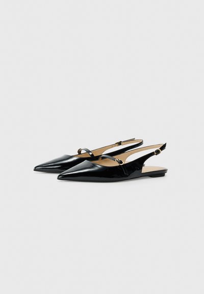 Musta kiiltävä nahkainen slingback-kengät, joissa on terävät varpaat, ohuet remmit ja pyöreät metallikoristeet sivuilla. Litteät pohjat.