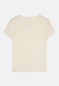 Kremo spalvos trumpomis rankovėmis dryžuotas marškinėlis su apvaliu kaklu ir mažu baltu "GAP" logotipu išsiuvinėtu ant krūtinės.