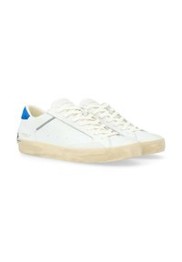 Sneakers bianchi in pelle con un accento blu sul tallone, suola in gomma beige e dettagli di cucitura a contrasto sui lati. I lacci sono bianchi.