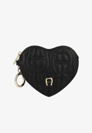 Heart-shaped black leather pouch with quilted texture, featuring gold hardware and a keyring attachment. Embossed logo detail on the front.