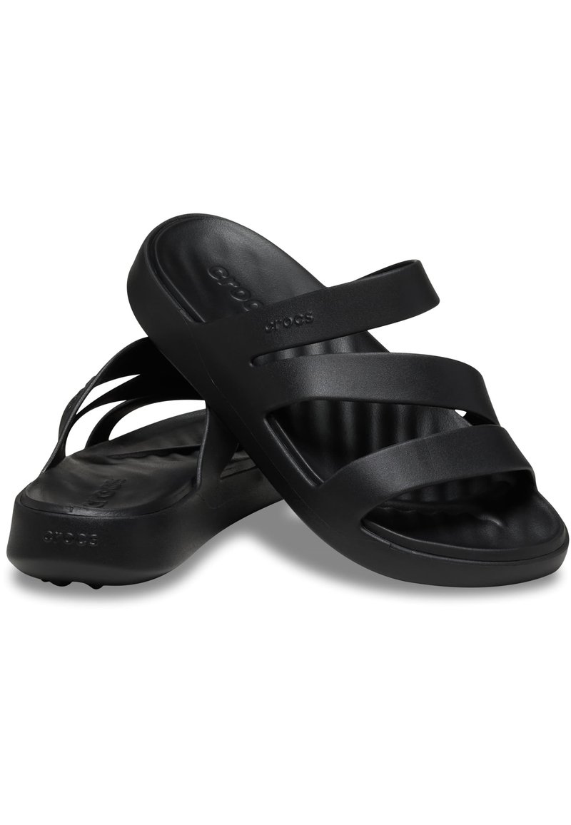 Zwarte slippers van flexibel materiaal, met twee brede banden, een gevormde binnenzool en een gestructureerde zool voor grip.