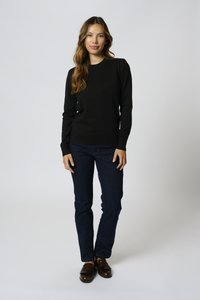 Pullover nero in maglia con maniche lunghe e collo rotondo. Abbinato a jeans blu scuro e mocassini marroni. Design semplice e aderente.