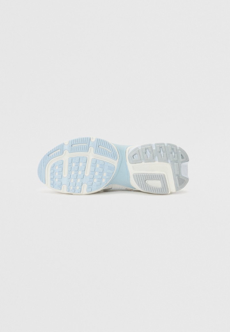 Suela de zapatilla deportiva azul claro con patrones de tracción de goma texturizada, rodeada por una entresuela blanca y acentos en azul claro.