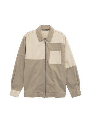 Katoenen jack met een ritssluiting, met een lichtbeige bovenstuk en een donkerbeige onderstuk, inclusief een borstzak.