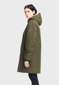 Oliven grøn parka med hætte, der har lynlåslukning, elastiske manchetter og en blød inderside, der strækker sig til midt på låret.