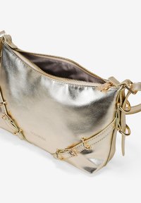 Bolso de mano metálico dorado con textura suave, cierre de cremallera y acentos decorativos de hardware. Interior forrado con tela suave.
