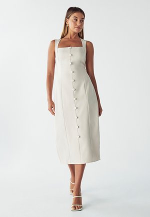 Helles beige Midikleid mit quadratischem Ausschnitt, das eine durchgehende Knopfleiste und breite Träger hat. Glatte Textur und figurbetonte Silhouette.